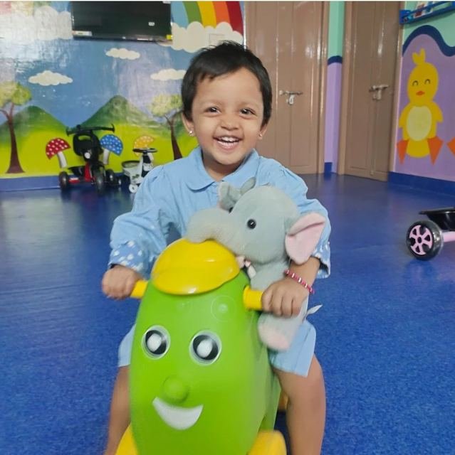 Smiling child playing with a soft toy at Kids Kingdom Playschool